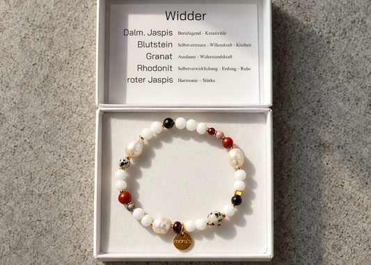 Helle Perlen, kräftige rote Steine und dunkle Akzente prägen das Widder-Armband. Der gesprenkelte Dalmatiner-Jaspis verleiht dem Sternzeichen-Schmuck seine charakteristische Optik – mit wählbaren Metallfarben und persönlicher Wunschprägung