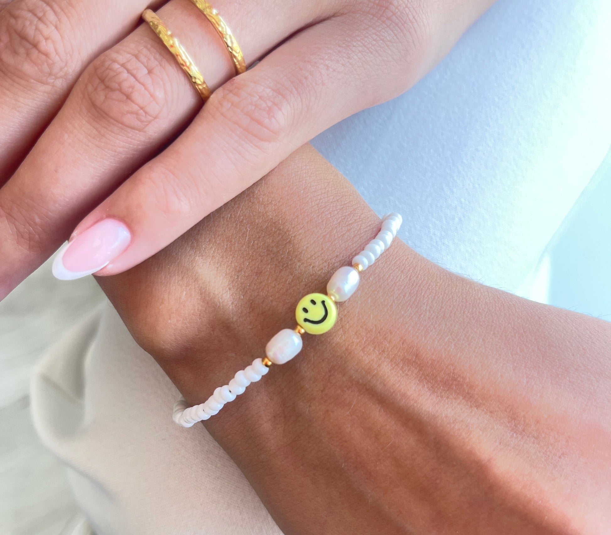 Personalisiertes Gute-Laune-Armband mit Smiley-Anhänger und Süßwasserperle.