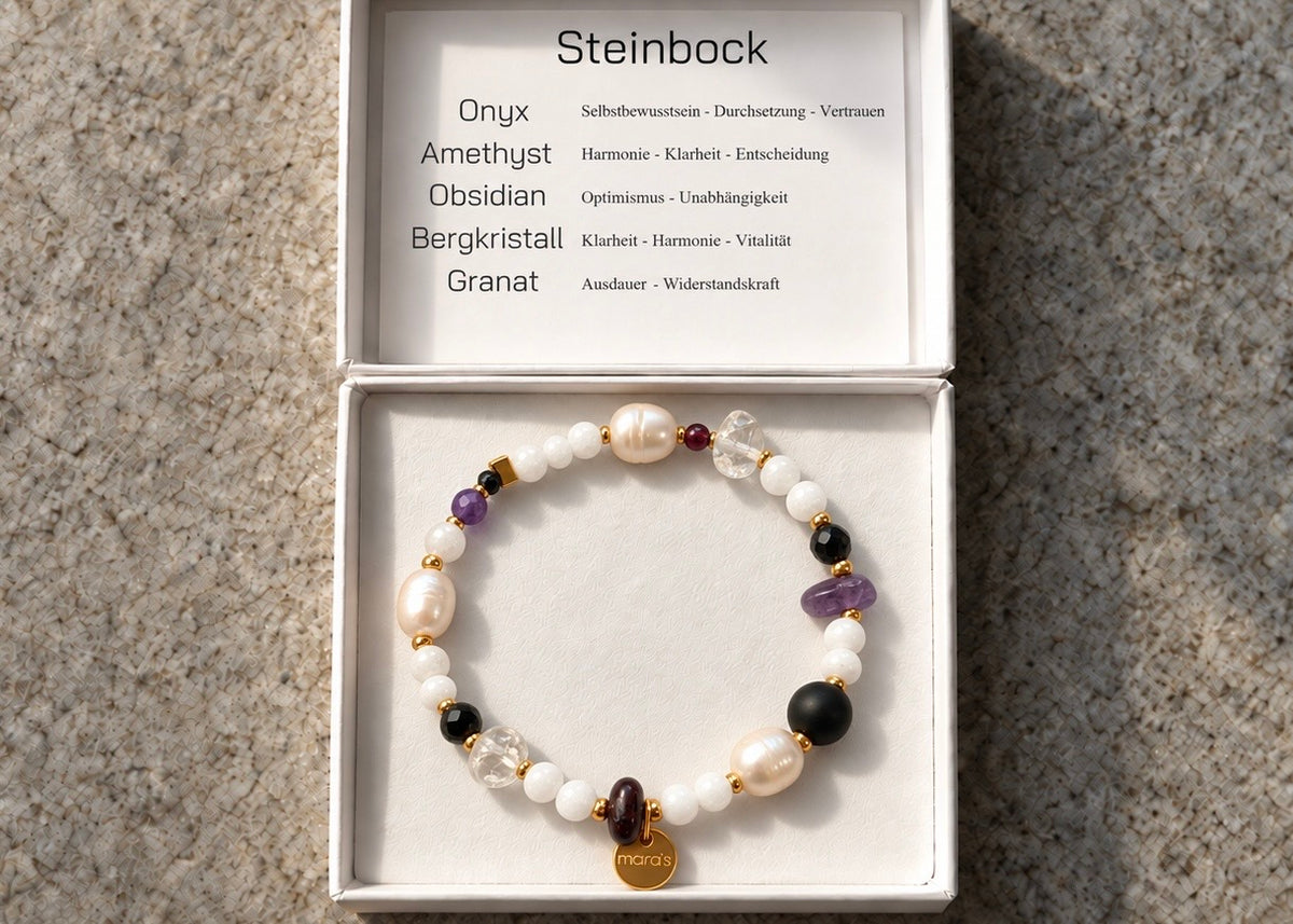 Edelsteinarmband für das Sternzeichen Steinbock mit hellen Perlen, schwarzen, violetten und dunkelroten Natursteinen, Bergkristallen und goldfarbenen Akzenten