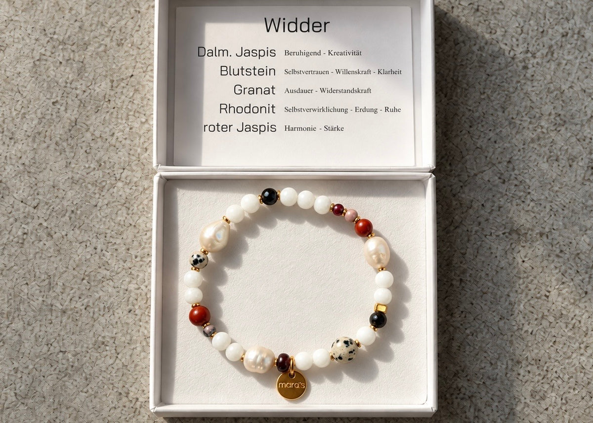 Helle Perlen, kräftige rote Steine und dunkle Akzente prägen das Widder-Armband. Der gesprenkelte Dalmatiner-Jaspis verleiht dem Sternzeichen-Schmuck seine charakteristische Optik – mit wählbaren Metallfarben und persönlicher Wunschprägung