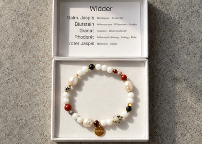 Helle Perlen, kräftige rote Steine und dunkle Akzente prägen das Widder-Armband. Der gesprenkelte Dalmatiner-Jaspis verleiht dem Sternzeichen-Schmuck seine charakteristische Optik – mit wählbaren Metallfarben und persönlicher Wunschprägung